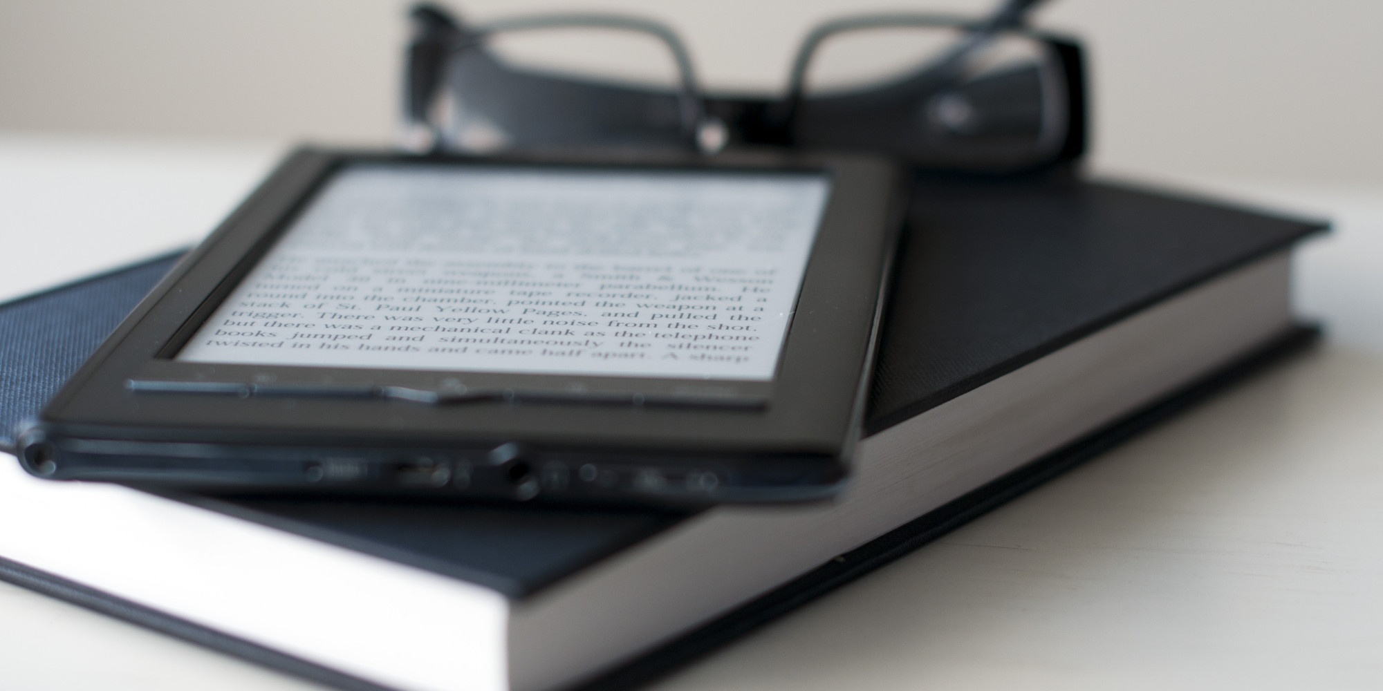E-Reader and book with reading glasses